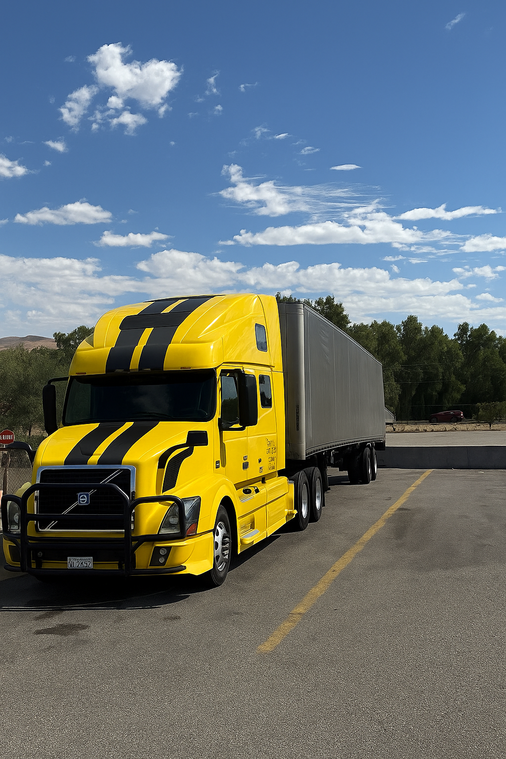 Yellow NK Extra Services Volvo semi truck pulling a dry van trailer